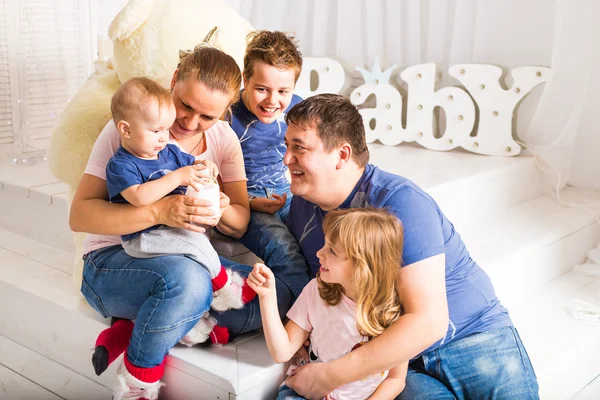 Famille heureuse avec 3 enfants assis sur le plancher du salon à la maison — Photo