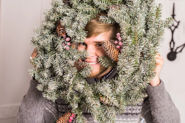 Killen har kul på fest. Mannen med en jul krans på hans ansikte begreppet ett roligt party på jul eller nyår — Stockfoto