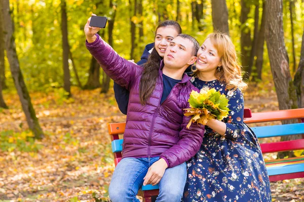 Lächelnde junge Familie macht Selfies an einem Herbsttag — Stockfoto