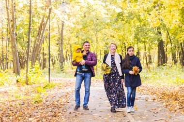 İki çocuklu aile sonbahar Park'ta yürüyordunuz
