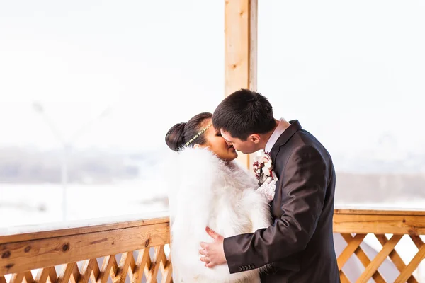 Beijo romântico noiva feliz e noivo no dia do casamento de inverno — Fotografia de Stock