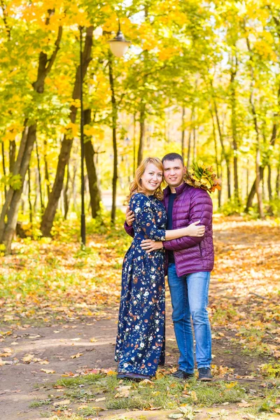 Kärlek, relation, familj och människor koncept - leende par kramas i höstparken — Stockfoto