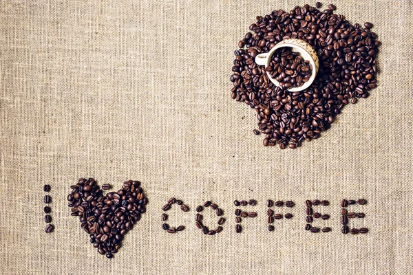 Надпись из кофейных зерен говорит, что я люблю кофе. пустое место для надписи. Знак сердца, символ. Напитки . — стоковое фото