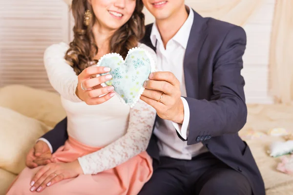 年轻夫妇抱着心形状枕头 — 图库照片