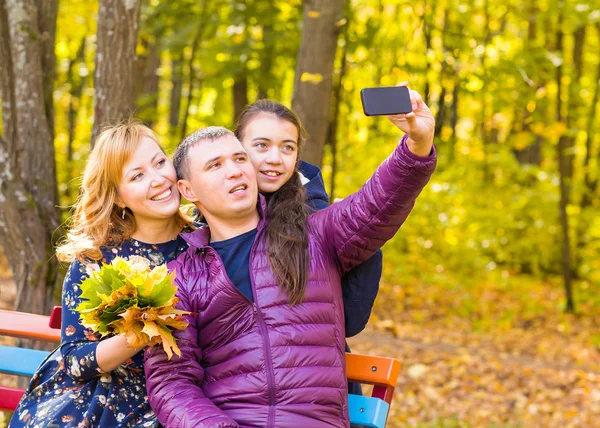 Aile, çocukluk, sezon, teknoloji ve insan kavramı - mutlu aile selfie sonbahar Park fotoğraf çekimi — Stok fotoğraf
