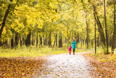 Genç anne yürüyüş sonbahar Park kızıyla birlikte