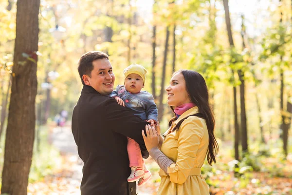 Feliz familia madre, padre y bebé en otoño naturaleza — Foto de Stock