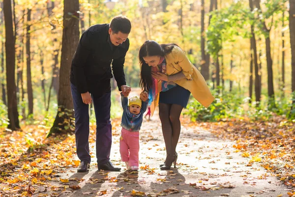 Sonbaharda parkta birlikte yürüyen dost canlısı bir aile. — Stok fotoğraf
