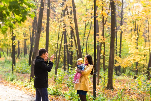 Familia feliz jugando en el parque de otoño — Foto de Stock