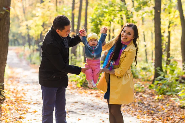 Lycklig familj promenader i parken under hösten tillsammans — Stockfoto