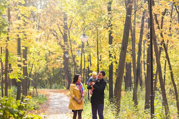 Feliz familia joven caminando por el camino afuera en otoño naturaleza . — Foto de Stock