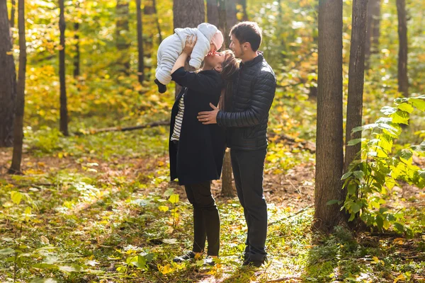 Retrato de pareja joven y feliz con la niña en el parque de otoño — Foto de Stock