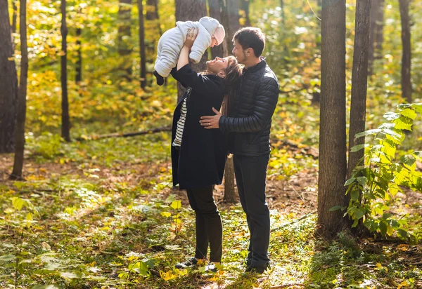 Retrato de pareja joven y feliz con la niña en el parque de otoño — Foto de Stock