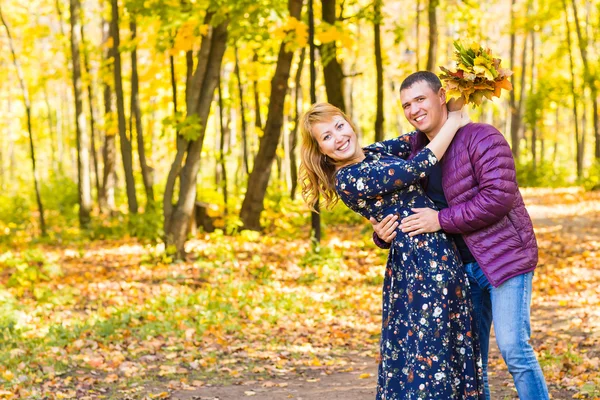 Miłość, związek, rodziny i ludzi pojęcie - para w parku jesień — Zdjęcie stockowe