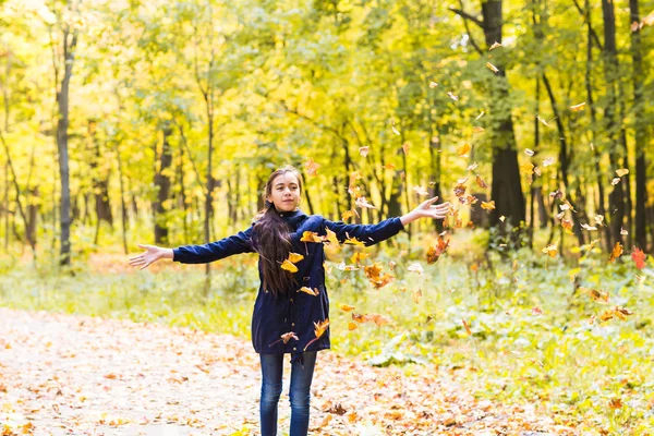 Привлекательная девушка-подросток бросает листья в воздух — стоковое фото