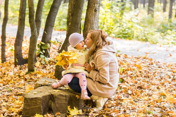 Jeune mère et sa petite fille s'amusent en automne — Photo