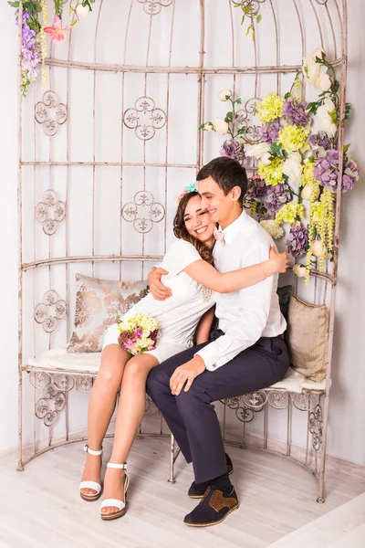 Happy stylish couple hugging and sitting on background of luxury interior. — Stock Photo, Image