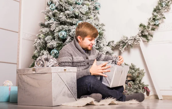 Natale - felice uomo caucasico sorridente apre scatola regalo — Foto Stock