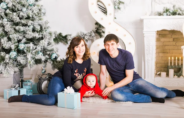 Familie zitten onder de kerstboom, moeder, vader en Baby kind in kamer ingericht — Stockfoto