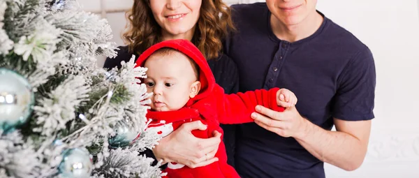 Babyjongen en ouders in de buurt van de kerstboom — Stockfoto