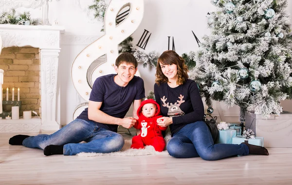 Familie zitten onder de kerstboom, moeder, vader en Baby kind in kamer ingericht — Stockfoto