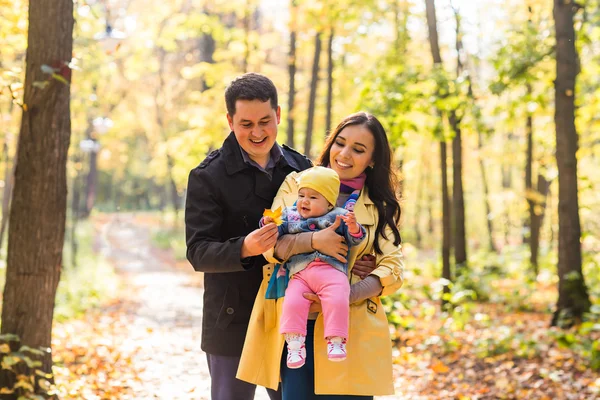 Glad ung familj med deras dotter spendera tid utomhus i parken hösten — Stockfoto