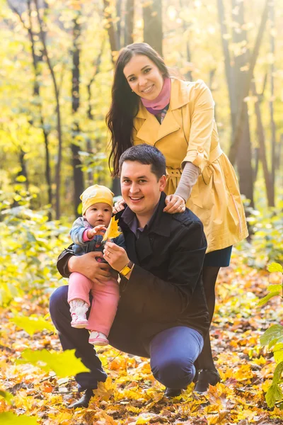 秋の公園で赤ちゃんと一緒にカップルを笑顔 - 愛、親、家族、季節、人の概念 — ストック写真