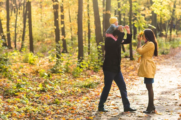 Amour, parentalité, famille, saison et concept de personnes - couple souriant avec bébé dans le parc d'automne — Photo