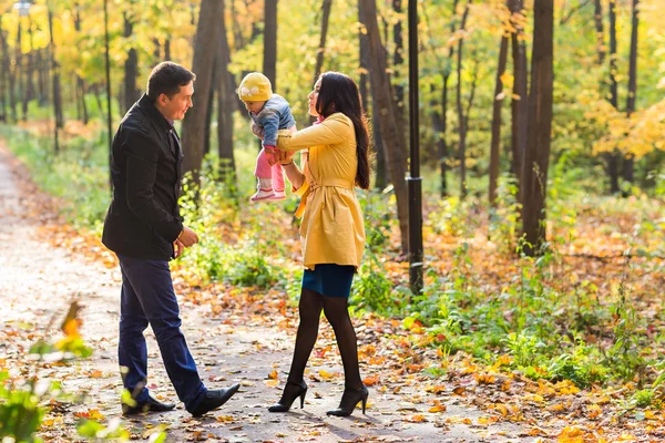 Kärlek, föräldraskap, familjen, säsong och människor koncept - leende par med baby i höst park — Stockfoto