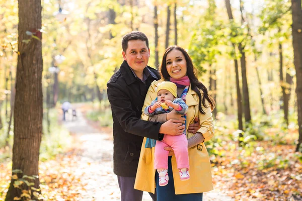 秋の公園での屋外の時間を費やして自分の娘と一緒に幸せな若い家族. — ストック写真