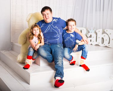 adam ve oturma odası gülümseyerek oturan iki çocuk