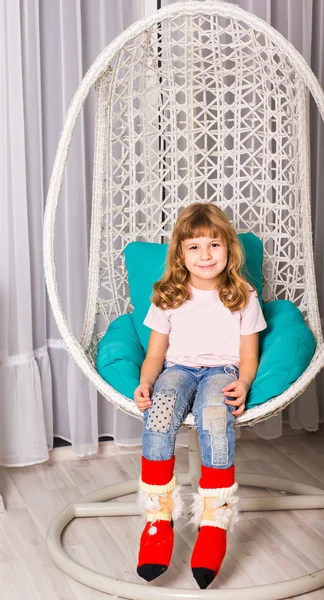 Porträt eines lachenden kaukasischen Mädchens, das im Stuhl sitzt und direkt in die Kamera blickt. — Stockfoto