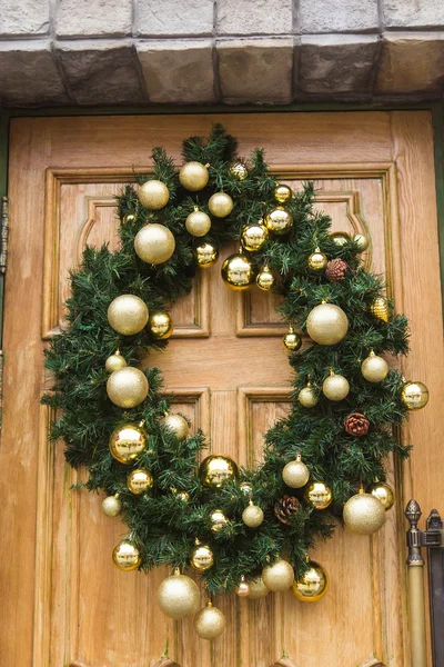 A grinalda de Natal com bugigangas e cones em uma porta . — Fotografia de Stock