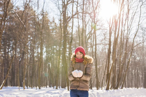 Різдвяний портрет дівчини на відкритому повітрі. Зимова жінка дме сніг у парку — стокове фото