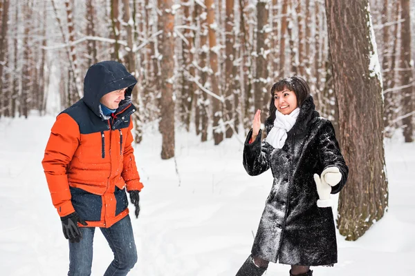 雪玉の戦い。冬のカップルが楽しんで屋外の雪で遊んで. — ストック写真