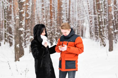 insanlar, sezon, sevgi, teknoloji ve eğlence kavramı - kış arka plan üzerinde smartphone ile mutlu çift