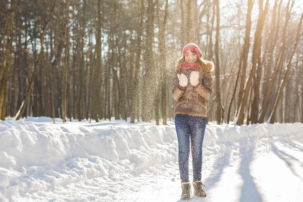 Natal menina retrato ao ar livre. Mulher de inverno soprando neve em um parque — Fotografia de Stock