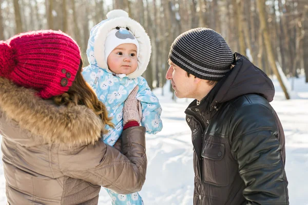 Parenthood, fashion, season and people concept - happy family with baby in winter clothes outdoors — Stock Photo, Image