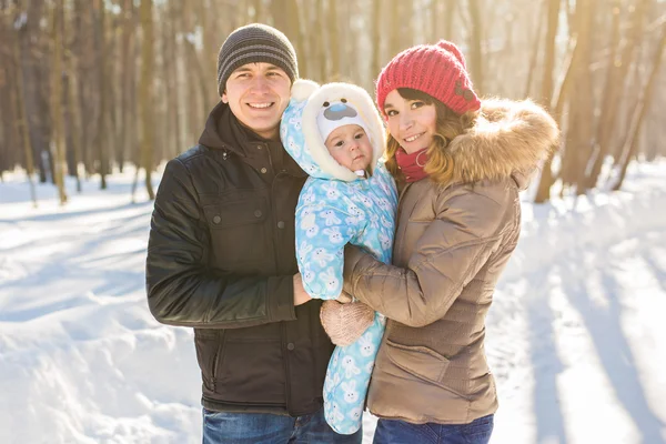 Parenthood, fashion, season and people concept - happy family with baby in winter clothes outdoors — Stock Photo, Image