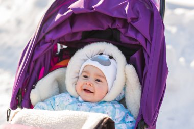 Sevimli gülümseyen bebek puseti içinde bir soğuk kış gününde oturma