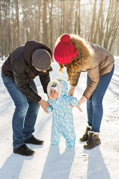 First steps of a baby in winter park — Stock Photo, Image