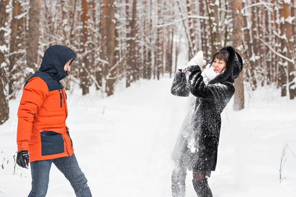 Bataille de boules de neige. Couple d'hiver s'amuser à jouer dans la neige à l'extérieur . — Photo