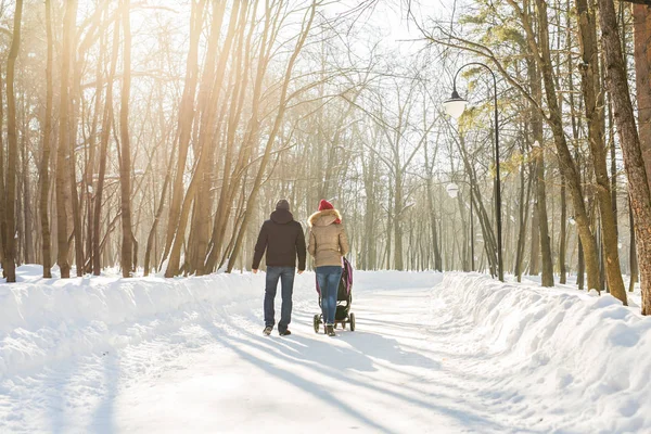 Père et mère avec poussette dans la forêt d'hiver — Photo