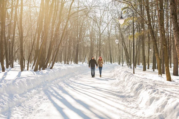 Casal feliz caminhando por uma floresta nevada no inverno — Fotografia de Stock