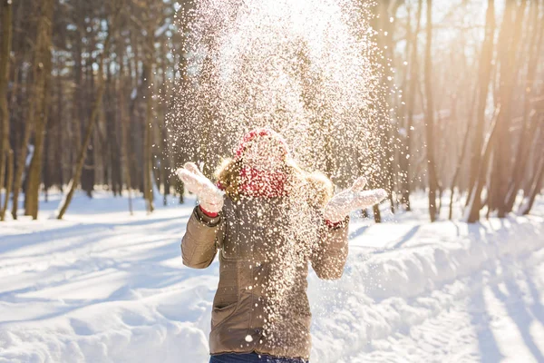 Beauté fille soufflant la neige dans le parc d'hiver givré. En plein air. Flocons de neige volants . — Photo