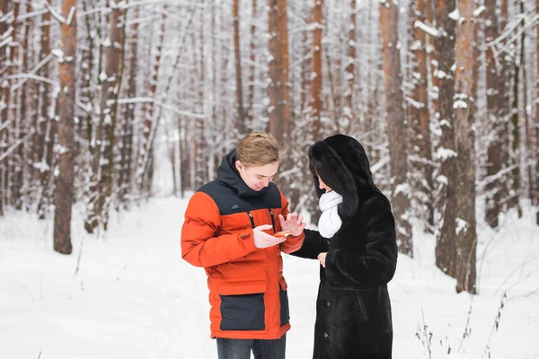 Щаслива пара консультує смартфон взимку на відкритому повітрі — стокове фото