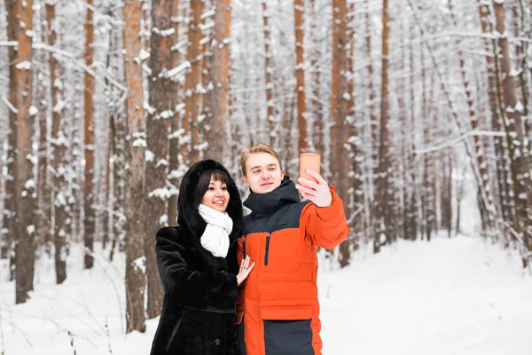 Felice coppia scattare selfie da smartphone in inverno — Foto Stock