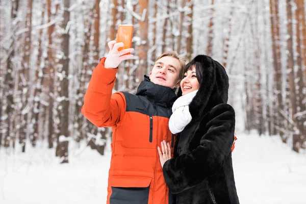 Casal feliz tomando selfie por smartphone no inverno — Fotografia de Stock