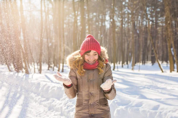 Beauté fille soufflant la neige dans le parc d'hiver givré. En plein air. Flocons de neige volants . — Photo