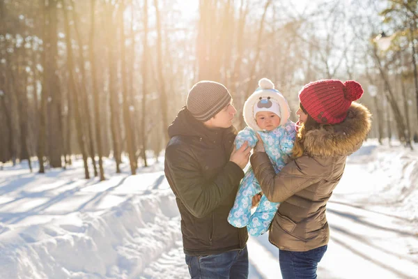 Parenthood, season and people concept - happy family with child in winter clothes outdoors — Stock Photo, Image